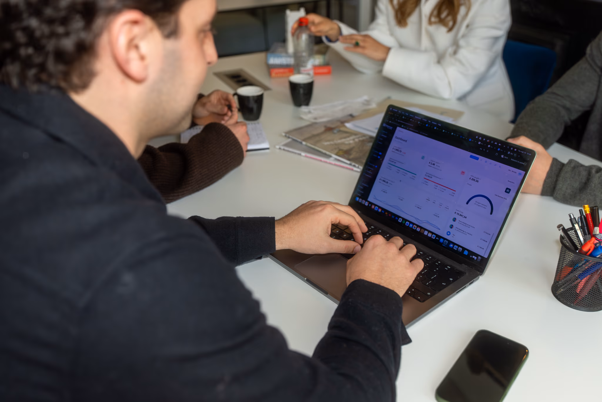 Business person working on a laptop showing a financial dashboard