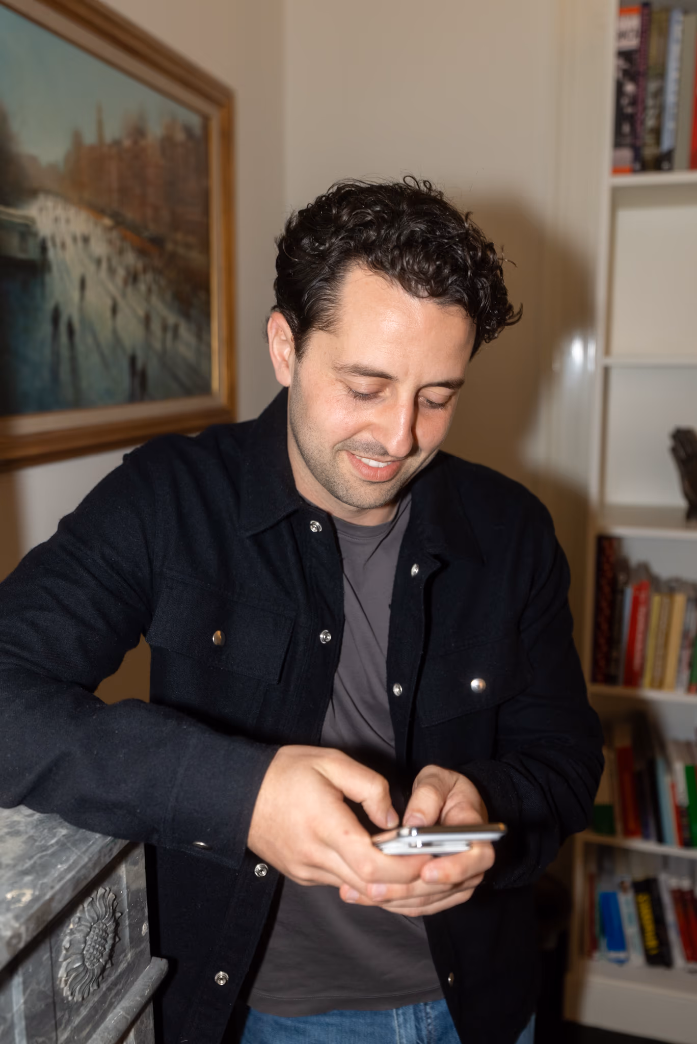 Smiling man using a smartphone indoors